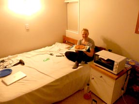 Bianca sitzt auf dem Bett neben dem Ofen