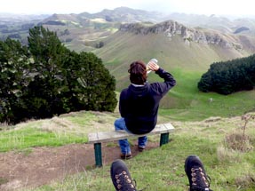 Thomas is sitting on the bench drinking